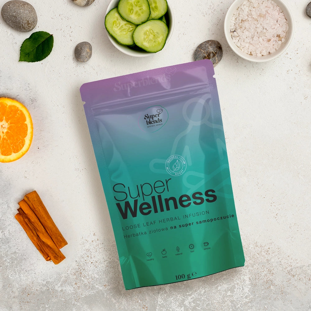 Torebka Super WELLNESS na jasnym blacie obok plastrów ogórka, pomarańczy, laski cynamonu i soli